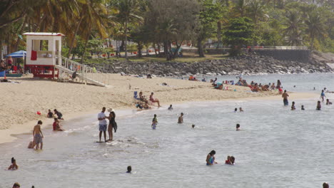 Slow-motion-shot-of-people-swimming-and-playing-on-crowded-beach-in-San-Juan,-Puerto-Rico