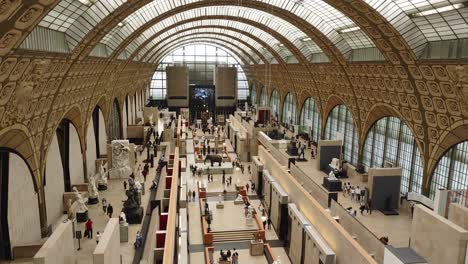 Galería-Principal-Del-Museo-De-Orsay-Con-Estatuas-Y-Visitantes-Y-Techo-De-Cristal-Alto
