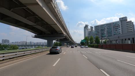 Driver's-POV-Road-traffic-along-the-Bridgeroad-near-Han-river,-Gangbyeonbuk-ro-road-,-Jayang-dong,-Seoul,-Korea,-Jun-27,-2021-afternoon