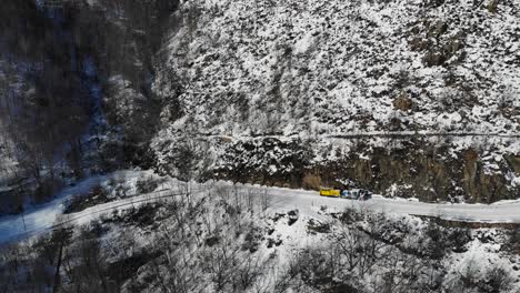 Aerial:-mountain-short-train-descending-among-snowy-mountains