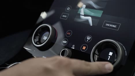 car-interior-man's-hand-touching-car-panel-buttons,-land-rover-velar-car-dashboard-air-conditioning-control-and-touch-screen-radio