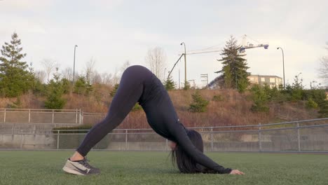 Athletic-woman-performs-downward-dog-yoga-stretch