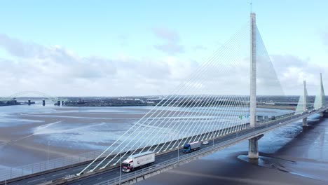 Mersey-gateway-landmark-aerial-view-above-toll-suspension-bridge-river-crossing-rising-tilt-down-orbit-right