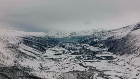 Aerial-drone-shot-overlooking-the-mountains,-the-ocean,-and-the-fiords-of-Kaafjord-in-Manndalen-Northern-Norway