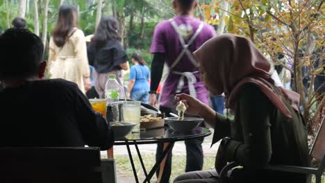 Yogyakarta,-Indonesia---May-26,-2022-:-Asian-man-having-lunch-together-with-moslem-woman-at-the-outdoor-cafe