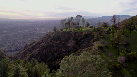 A-drone-shot-of-a-clearing-on-an-overlook-at-the-top-of-a-mountain-at-golden-hour