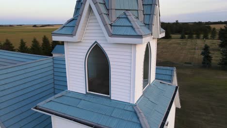 Die-Glocke-In-Einem-Makellosen-Weißen-Kirchturm-Einer-Hölzernen-Landkirche-Im-Ländlichen-Alberta,-Kanada-Bei-Sonnenuntergang