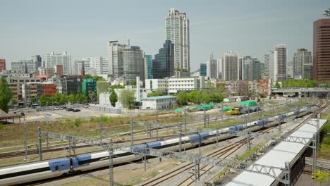Tren-Ktx-Que-Viaja-A-La-Estación-De-Seúl-Con-Panorama-Del-Centro-De-La-Ciudad---Vista-Elevada