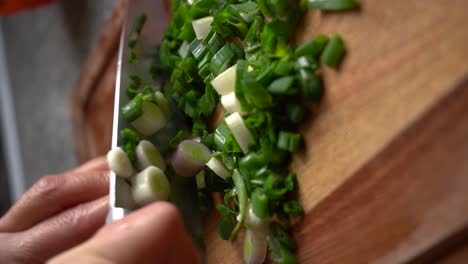 Vertical-Shot-Of-Spring-Onions-Cutting-On-Wooden-Chopping-Board