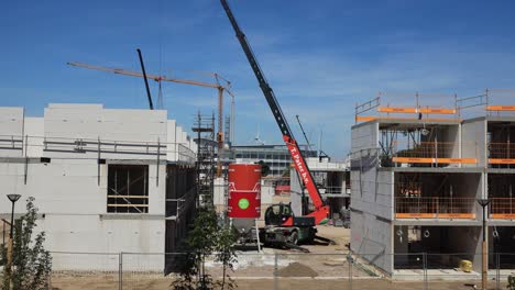 Day-in-the-life-of-a-crane-on-a-construction-site-time-lapse-moving-around-dispersing-building-material-where-needed-at-PUUR12-urban-development-project-against-a-blue-sky