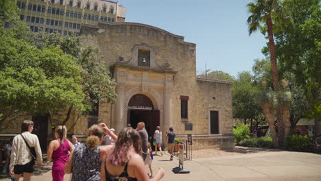 A-Group-of-Tourists-walk-outside-the-Alamo-on-a-summer-day