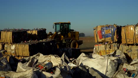 A-bulldozer-passes-by-compacted-waste-in-the-field-of-a-waste-processing-plant