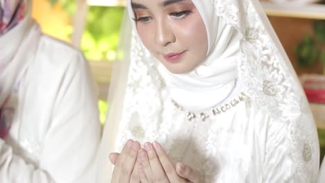 Asiatische-Muslimische-Frau,-Die-Mit-Offenem-Arm-Betet-Und-Einen-Weißen-Hijab-Trägt