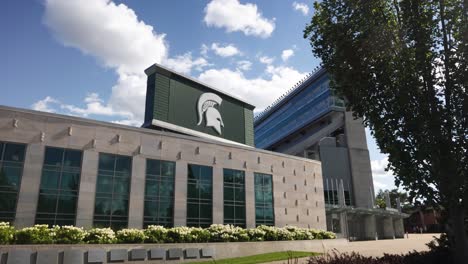 Exterior-of-Spartan-Stadium-on-the-campus-of-Michigan-State-University-in-East-Lansing,-Michigan-with-slow-motion-pan-left-to-right-and-trees-blowing-in-the-wind