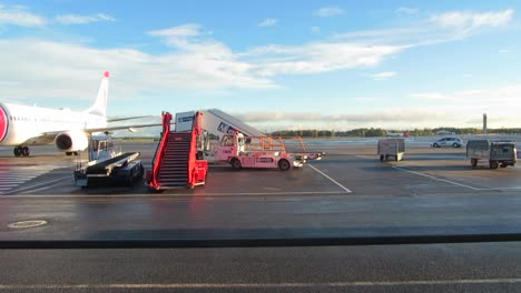 Luggage-carts-driving-past-at-Oslo-Gardermoen-airport,-Norway,-September-2015