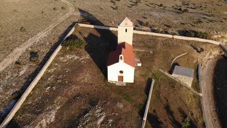 Beautiful-traditional-small-island-church-in-the-Adriatic,-aerial-view-approaching-from-above