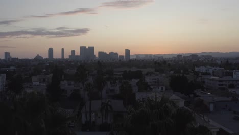 Beautiful-aerial-fly-over-palm-trees-during-sunset-in-Los-Angeles