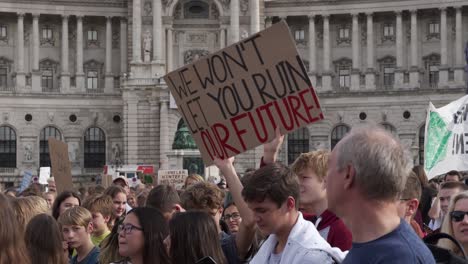 Crowd-of-protestors-with-sign-saying-"We-won't-let-you-burn-our-future"-during-fridays-for-future-climate-change-protests-in-Vienna,-Austria