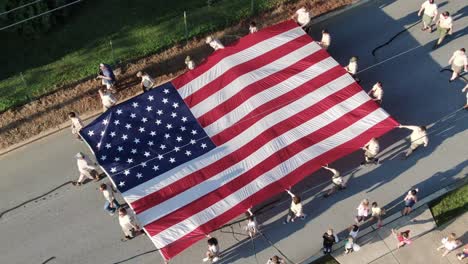 Aerial-top-down-birds-eye-view-of-Boy-Scouts-of-America-carrying-US-star-and-stipes-in-Lititz-PA-USA-parade-July-4