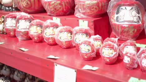 Darumo-dolls-lined-up-at-a-market-in-Kyoto,-Japan-soft-lighting-slow-motion-4K
