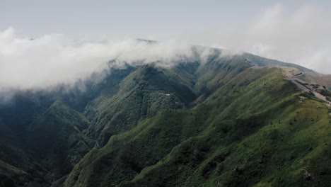 Aerial-video-footage-of-tropical-rainforest-on-Madeira-with-moving-clouds-and-lush-vegetation,-slow-side-movement