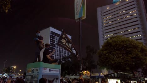Protesters-sitting-on-top-of-a-telephone-booth-waving-"Liberate-Hong-Kong"-flag-during-the-Oct-rally,-Hong-Kong