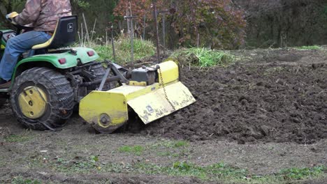 A-man-uses-a-tractor-rototiller-in-the-garden-just-before-winter