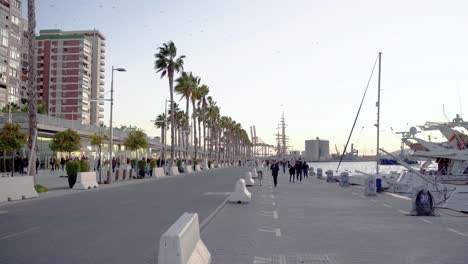 Evening-walk-on-the-famous-Paseo-del-Muelle-Uno-in-Malaga,-next-to-the-port