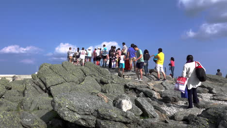 Conway,-New-Hampshire---July-3,-2019:-A-queue-of-people-waiting-to-take-selfies-at-the-summit-of-Mount-Washington-in-Conway,-New-Hampshire-on-July-3,-2019