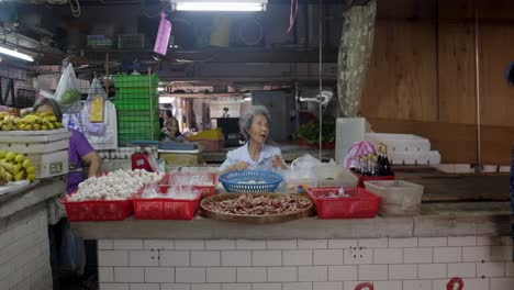 Ambiente-De-Mercado-Taiwanés,-Mujer-Sentada-Comiendo-Comida-Rápida-Tailandesa-Variada-Con-Cajas-De-Alimentos-Al-Por-Menor