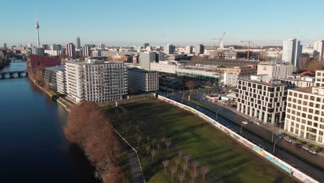 Berlin-wall-from-the-river-Spree-with-a-drone-flying-along-the-river-and-showing-the-Berlin-TV-antenna-made-in-4k-24fps