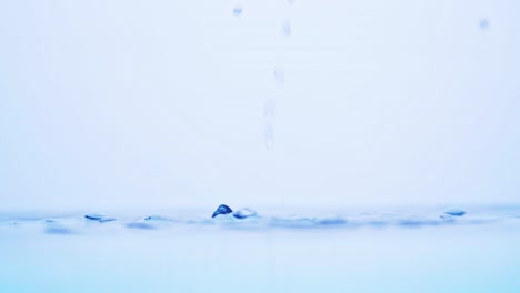 Wasserspritzeroberfläche,-Die-Den-Rahmen-Mit-Zeitlupe-Füllt,-Der-Wassertropfen-Und-Winkende-Flüssigkeit-Mit-Einer-Luftblase-Auf-Weißem-Hintergrund