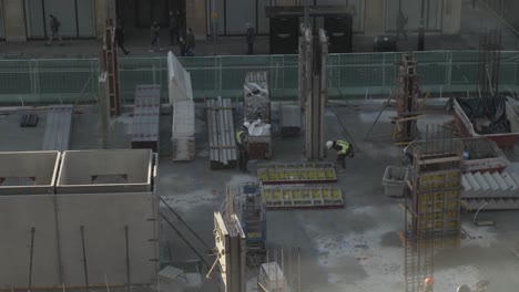 Two-Workers-Checking-Concrete-Retainer-Walls-On-Floor-At-Constructions-Site