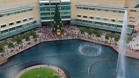 Luftaufnahme-Des-KLCC-Einkaufszentrums-Von-Hinten-Mit-Park-Und-Springbrunnen-Während-Der-Weihnachtszeit-Mit-Weihnachtsbaum-In-Kuala-Lumpur,-Malaysia