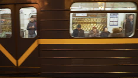 Tight-static-shot-of-metro-train-passing-by-with-passengers-in-St