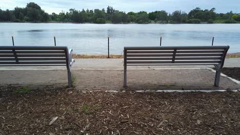 Two-benches-by-the-river-walk-in-the-public-park-in-a-cloudy-morning