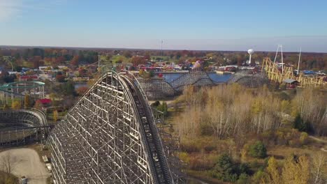 Aerial-of-rollercoasters-and-nature-in-sunlight-at-amusement-park