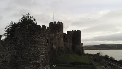 Historical-medieval-Conwy-castle-landmark-aerial-view-close-to-wall-moving-forward