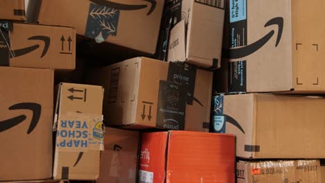Person-puts-an-empty-Amazon-box-with-other-boxes-ready-to-be-disposed-of