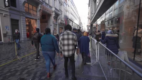Massen-Von-Besuchern-Laufen-Durch-Die-Beliebte-Einkaufsstraße-Rue-Neuve-In-Brüssel,-Sie-Tragen-Aufgrund-Der-örtlichen-Covid-19-Verordnung-Obligatorische-Gesichtsmasken