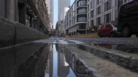 Cars-stopping-on-central-London-street-reflected-in-a-puddle