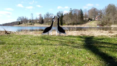 Wooden-bird-art-on-a-sunny-day-next-to-lake,-Grafsnas-Castle,-Sweden,-wide-shot