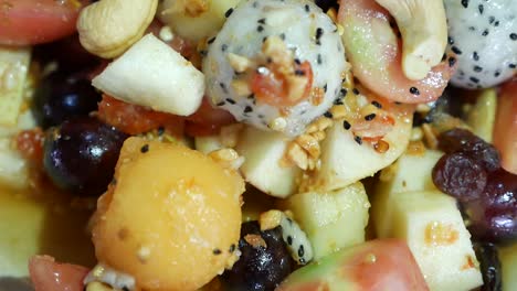 Nahaufnahmen-Von-Exotischen-Früchten-Im-Thailändischen-Stil,-Somtum-Mit-Süßem-Und-Salzigem-Dressing,-Darunter-Drachenfrucht,-Cashewnuss,-Traube,-Guave,-Melone-Und-Tomate