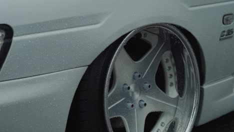 Nissan-Laurel-C35-Luxury-Alloy-Wheel-Rim-and-White-Car-Body,-Close-Up-Detail-Slow-Motion