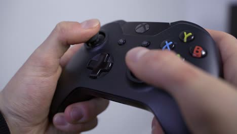 Hands-playing-with-an-Xbox-One-videogame-controller,-close-up