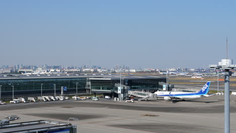 View-of-Haneda-airport-terminal,-two-aircraft-taxiing-in-background