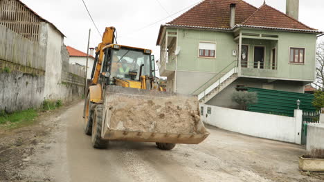 Wheel-Loader-Machine-Moving-On-The-Road-During-Construction-At-Village-In-Leiria,-Portugal