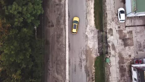 Aerial-view-of-a-yellow-Opel-Insignia-car-speeding-on-a-road-doing-some-slalom