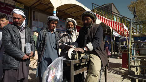 Einheimischer-Schärft-Eine-Alte-Metallsäge-Mit-Tretschleifer-In-Den-Straßen-Von-Bamyan,-Afghanistan