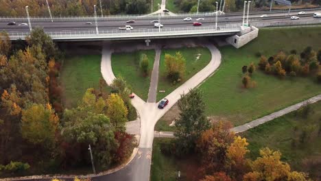 Aerial-view-of-black-and-red-Opel-Grandland-and-Ford-Kuga-cars-speeding-on-a-underpass-road